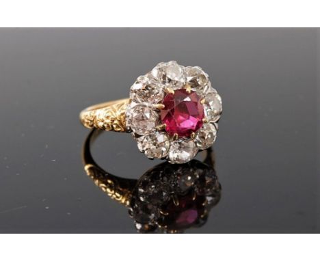 A ruby and diamond ring , the central round ruby, approx. 6.9mm diameter x 4mm deep, surrounded by eight old European cut dia