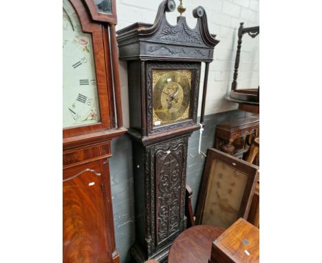 An 18th century carved oak longcase clock with brass dial by Thomas Lanson, Kighley. Condition- comes with weights and pendul