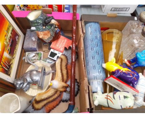 Two boxes of assorted items including Party Pigs, a Royal Doulton character jug, an eastern oil painting, a fish handled walk