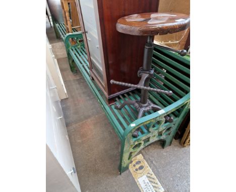 A green metal garden bench. 