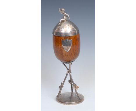 A Victorian E.P.N.S mounted oak pedestal cup and cover, Bacchic putto finial, the cover and base chased and applied with frui