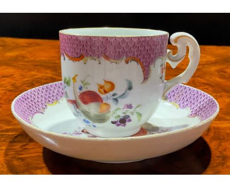 A Meissen coffee cup and saucer, painted with ripening fruit and nuts, under a puce scale border, gilt line rim, the saucer 1