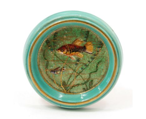 An early 20th century Art Pottery circular wall plaque, of small proportions, decorated with fish amongst seaweed, painted in
