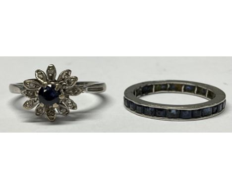 An unmarked white metal eternity ring, set with a band of blue stones, size N, 2.4g; an unmarked cluster ring, 4g (2) 