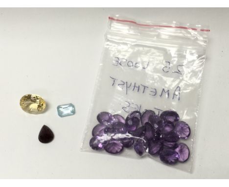 25 loose amethyst stones, a ruby, a topaz and a large citrine.
