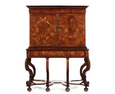 A William and Mary kingwood oyster veneered and rosewood cabinet on stand The upper part with a moulded overhanging cornice a