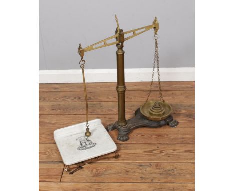 A set of vintage weighing scales produced by CWS of Manchester on cast iron base with ceramic weighing plate.  
