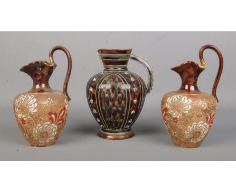 Elizabeth Atkins for Doulton Lambeth, a glazed stoneware pitcher along with a pair of Doulton Lambeth Slaters patent ewers. T