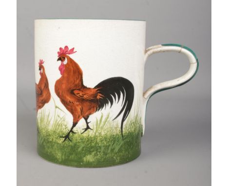 A Wemyss tankard decorated in the black cockerel and hens pattern. Height 14cm.  Repair to handle.