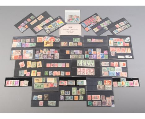 A collection of vintage and antique world stamps. Includes Canadian War Tax one cent, Nouvelles Hebrides mint stamps, Indian,