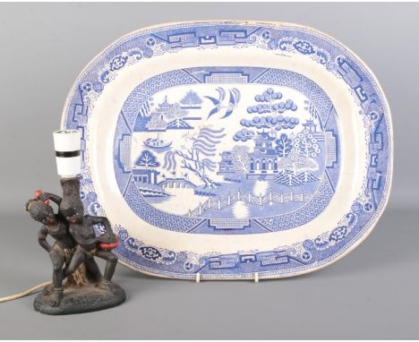 An antique blue and white meat plate bearing the 'Old Willow' pattern, together with a composite table lamp formed as two chi