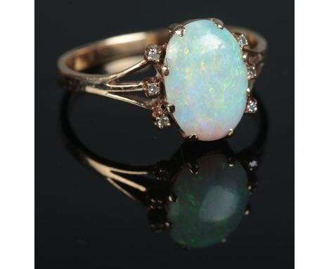 A 9ct gold ring set with large opal stone surrounded by 6 small diamonds 2.66gR1/2  