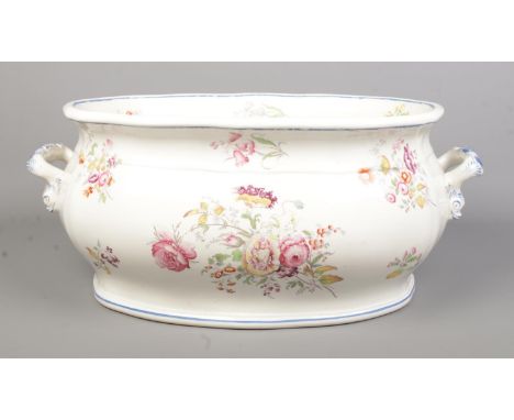 A Victorian ceramic footbath decorated with flowers. Height 21cm, Width 53cm.  Some paint wear. Slight crazing to interior.