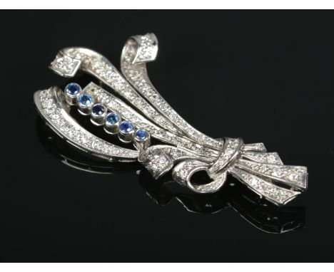 An Art Deco platinum, diamond and sapphire scroll brooch. Length 6cm. 9.64g.  