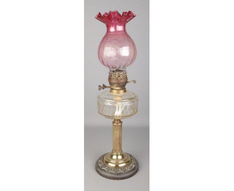 A early Twentieth Century 'British Made' oil lamp, featuring cylindrical Corinthian column, glass reservoir and frosted pink 