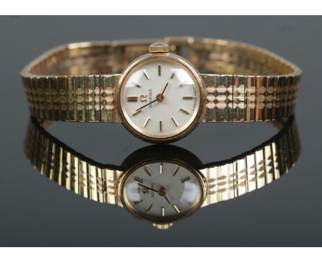 A ladies 9ct gold Omega manual wristwatch on 9ct gold Omega strap. With box and papers. 18.9g.  Damage to box. Watch running.