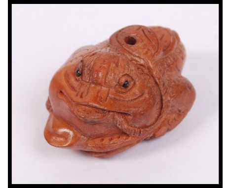 An unusual Oriental wooden carving netsuke in the form of a toad.