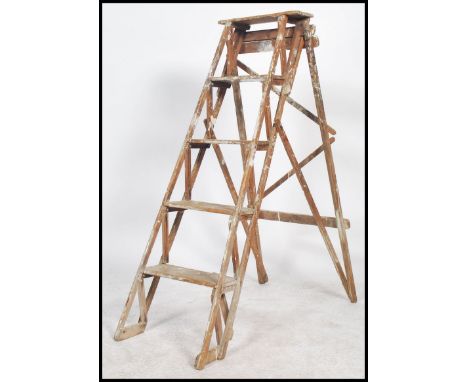 An early 20th century Lattice side wooden Industrial pine wood step ladder. Of A-frame shape having latticed sides and reeded