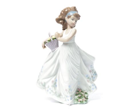 A Lladro ceramic figure of a girl holding a basket of flowers entitled floral path. Impressed marks to base 6646. Measures: 2