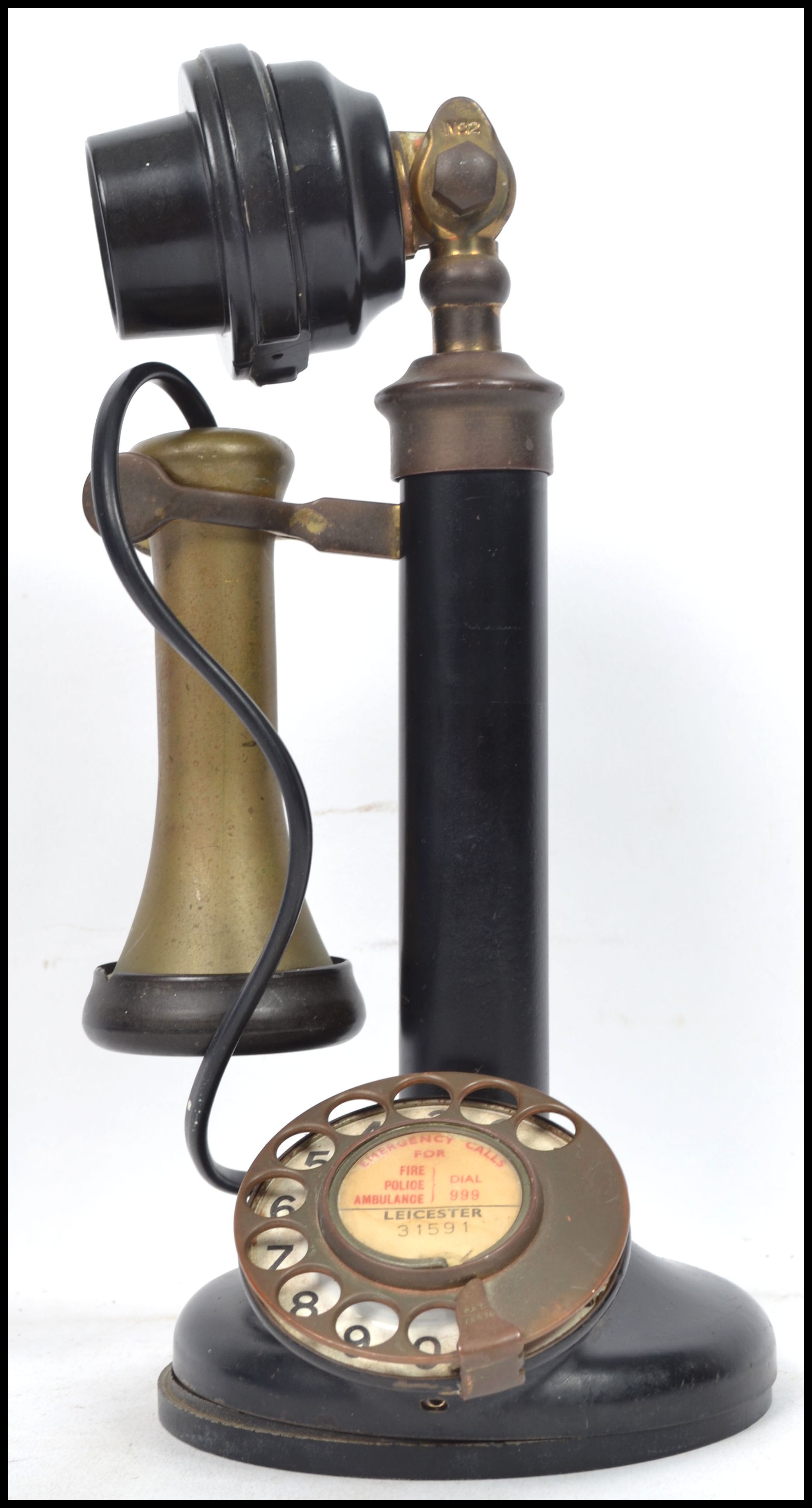 A vintage 20th century ring dial stick telephone having a brass ...