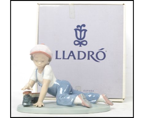 A Lladro ceramic figure titled " All Aboard ". No. 07619, retaining original box. Measures: 12cm high x 8cm deep x 21cm wide.