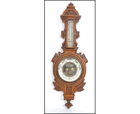 A Victorian oak carved aneroid barometer having an enamelled face and Fahrenheit gauge.Measures 64 cm high and 22 cm wide