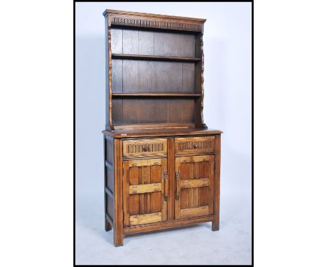 A 20th century Ercol Golden Dawn elm dresser, having three tier open plate rack over base fitted with two frieze drawers and 