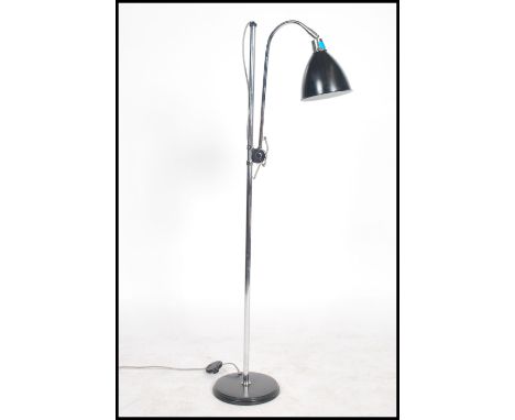 A retro 20th century anglepoise standard lamp raised on a ebonised circular base with an adjustable chrome stem and a black p