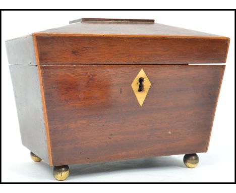 A 19th Century mahogany tea caddy, of sarcophagus form hinging to reveal a twin lead lined interior with both lids intact fit