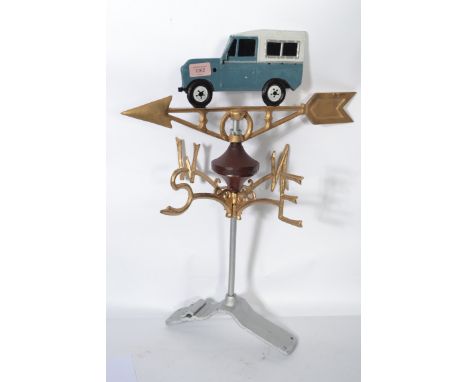 A vintage 20th century cast iron motoring related weather vane with gilt detailing and land rover atop.