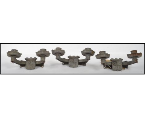 A collection of 3 20th century gothic revival eclesiastical twin light sconces of strap form cast in relief