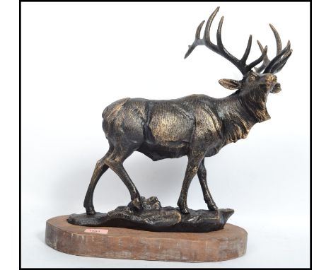 A very large vintage 20th century cast iron stag figurine raised on a naturalistic base with wooden plinth. Measures 47 cm hi