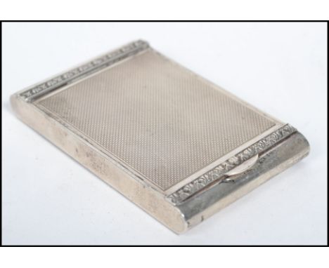 A silver hallmarked vintage ladies compact by Dyas Beverley Hampton of rectangular form having an engine turned decoration wi