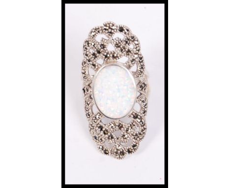 A large silver and marcasite art deco style ring having a large central opal stone, weighs 10 grams size Q.