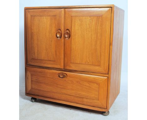 An Ercol 20th century light elm wood ' Windsor ' pattern serving / entertainment cabinet - cupboard. Raised on ball castors w