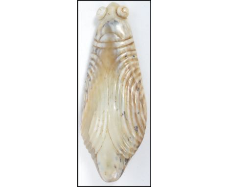 An unusual large  Chinese carved white ? russet jade pendant in the form of a scarab beetle with ribbed wings and raised eyes