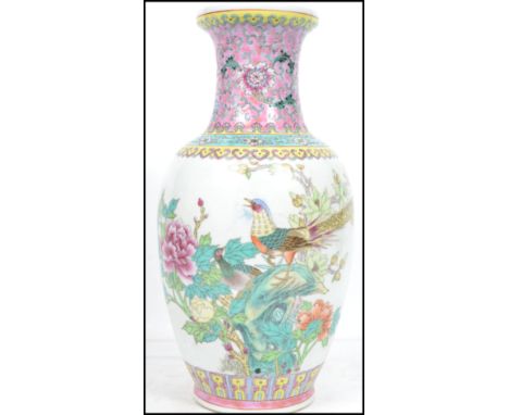 An Oriental Chinese ceramic vase having a white ground decorated with famille rose birds and flowers and a pink floral decora