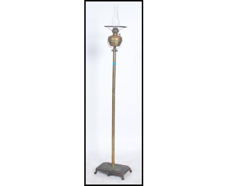 A late Victorian brass floor standing oil / standard lamp, the brass column supported by a heavy cast rectangular base. Measu