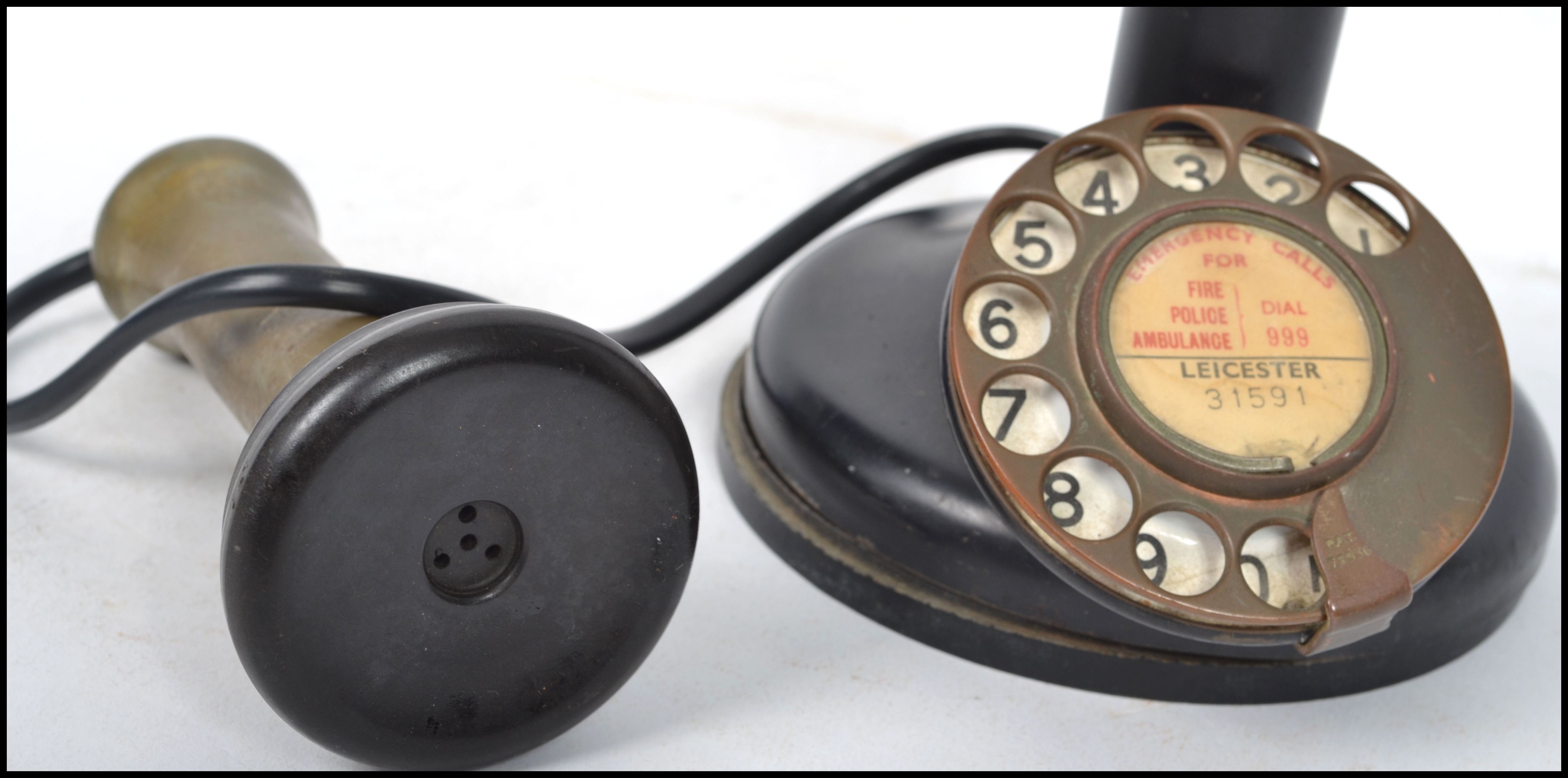 A vintage 20th century ring dial stick telephone having a brass