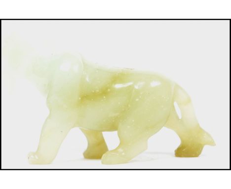 An Oriental Chinese jade carving of a dog / temple lion with open jaw and hanging tongue. Measures: 7cm high x 4cm wide x 12c