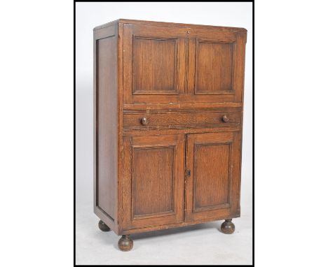 A vintage 20th century 1950's full front oak cocktail cabinet bar with mirror to back, lemon squeezer, and cupboard bellow. D