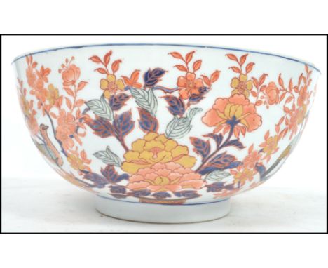 A large Oriental ceramic bowl having a white ground with decoration of birds and flowers having ochre red character marks to 