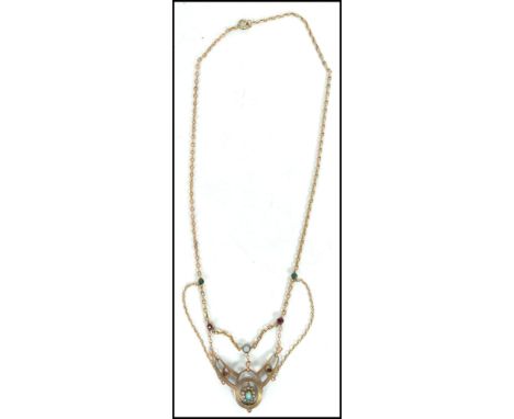 An early 20th century Art Nouveau gold tone metal necklace having a belcher link chain with green and red stone spacers with 