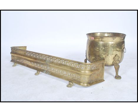 A late 19th century brass fire fender together with a lidded Art's and Craft's coal scuttle. Measures 120cm long x 22cm high.