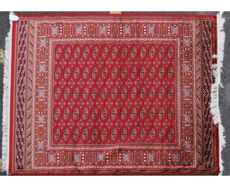 A large Iranian / Persian Bokhara carpet - rug having red ground with geometric decoration and borders. Measures 1.90 x 1.40 