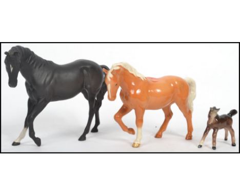 A group of three Beswick ceramic pony / horse figures to include a Matt Black Beswick horse, a Palomino, head tucked, leg up,