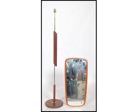 A vintage teak wood framed wall mirror of angular form being frameless together with a retro teak and brass wood standard lam