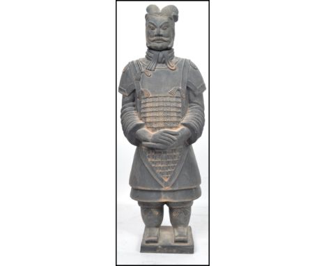 A large Oriental Terracotta  army figure of a soldier raised on a square plinth base with character marks to front. Measures 