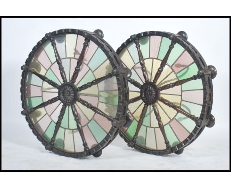 A pair of large 20th century coloured and leaded glass ceiling light fixtures in the form of ships wheels - cartwheels having