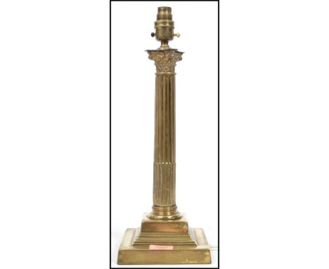 A vintage 20th century brass table lamp raised on a stepped square base with central classical column with scrolled top. Meas